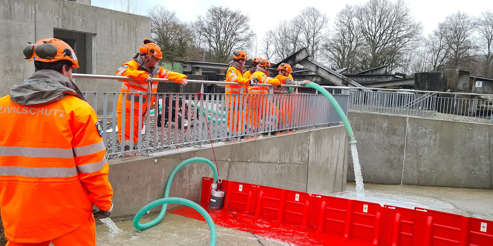 Zivilschutzangehörige errichten eine mobile Hochwassersperre